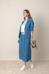 Pollera midi de jean azul, corte recto con tajo frontal, cintura elastizada con cinto y bolsillos laterales.
