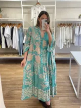 Vestido largo de viscosa color turquesa con estampado floral en tonos beige. Diseño holgado con mangas 3/4 y cuello en V abotonado.