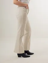 Pantalón de jean azul oscuro, de corte recto y tiro alto, con bolsillos delanteros y traseros. Presenta costuras verticales en el frente.