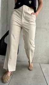 Pantalón color beige de lino, corte recto con abertura en el ruedo.