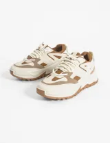 Zapatillas urbanas blancas con detalles en negro, cordones negros y suela chunky.