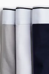 Pack de tres calzoncillos tipo trunk en punto elástico de algodón, color gris, blanco y azul marino, con cintura elástica blanca con una fina línea negra. Confeccionados con la tecnología Lycra® Xtra Life™.