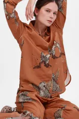 Camisa color almendra con estampado de leopardos alados, lunas y constelaciones.