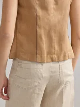Chaleco color beige de lino con corte entallado y cierre frontal con botones de madera.