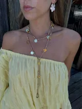 Collar largo con doble cadena fina color bronce, adornado con cuentas plateadas y doradas, y dijes circulares colgantes.