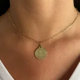 Collar dorado con cadena de eslabones alargados y dije redondo con la imagen de San Benito.