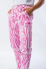 Pantalón babucha con estampado de cebra en fucsia y blanco, de corte ajustado, cintura elástica y tejido liviano.