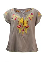 Blusa color taupe de mangas cortas con bordados florales en amarillo y fucsia. Tiene escote redondo con lazo y borlas amarillas.