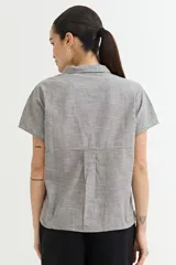 Camisa gris sin mangas de lino con cuello clásico y cierre frontal con botones.