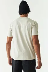 Remera de manga corta color ladrillo, con cuello redondo y estampado con texto y diseño abstracto en el frente.