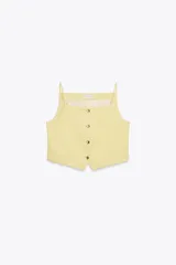 Chaleco amarillo pálido con cuello cuadrado, tirantes finos, falsos bolsillos de vivo y cierre frontal con botones.