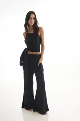 Pantalón oxford negro con brillos, de tiro alto y corte acampanado.