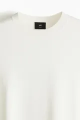 Remera blanca de punto fino suave con cuello redondo y corte ajustado.