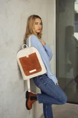 Mochila de cuero en color beige con detalles en gamuza marrón, diseño práctico y elegante.