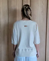 Remera de algodón color beige, con mangas 3/4 y un diseño cómodo para media estación.