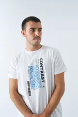Remera color ocre con cuello redondo y mangas cortas. Estampado frontal con la palabra "CONTRAST" en mayúsculas y un diseño abstracto en blanco y negro.