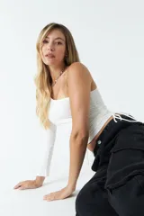 Top asimétrico blanco de una sola manga con jaretas ajustables en ambos lados del torso para regular el largo.