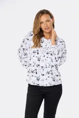 Blusa blanca estampada con hojas en color azul, de manga larga abullonada y cuello redondo.