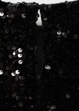 Vestido corto negro de fiesta con lentejuelas, manga larga abullonada, cuello redondo y abertura en la espalda con cierre de botón.