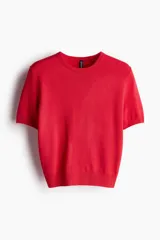 Remera de punto fino color rojo, de corte entallado, con cuello redondo y mangas cortas.