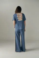 Top azul de manga corta con escote redondo y detalle de tiras en el frente.