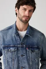 Campera de jean celeste, corte recto, con cuello clásico, cierre frontal con botones metálicos, bolsillos con solapa abotonados en el pecho y bolsillos laterales.