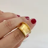Anillo dorado de acero quirúrgico hipoalergénico con baño en oro 18K, de diseño grueso y forma irregular.