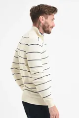 Sweater de tejido de punto color crudo con rayas horizontales finas en color azul marino. Presenta cuello alto con medio cierre frontal y puños y ruedo acanalados.