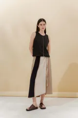 Falda midi portafolio con cruce, confeccionada en lino y algodón. Diseño con cortes verticales y detalles desflecados.