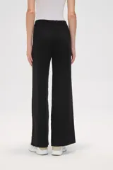 Pantalón de punto color crema, de corte ancho y tiro alto, con estampado animal print en los laterales.