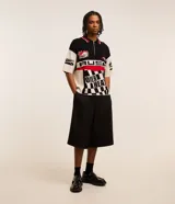 Camisa polo masculina de punto, corte boxy, con cuello con cremallera, manga corta y estampado estilo automovilismo con lettering.