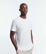 Remera blanca de corte regular, confeccionada en media malla con textura diferenciada. Tiene cuello redondo y mangas cortas.