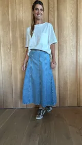 Pollera midi de jean celeste con corte en A y cintura elastizada.