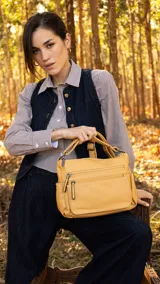 Cartera de cuero color borgoña, con correa larga regulable, dos bolsillos frontales con cierre y un bolsillo trasero con cierre.