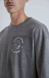 Remera gris melange de manga corta con cuello redondo y calce oversize. Estampado en el frente con una ilustración de una figura femenina y la inscripción "El Mundo".