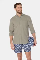 Short de baño celeste con estampado de flores blancas, cintura elástica con cordón ajustable, bolsillos laterales y suspensor de malla fina.