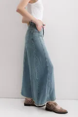 Falda larga de jean celeste, con corte sirena y abertura frontal.