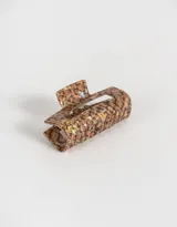 Broche rectangular de acrílico con estampado animal print en tonos marrones y beige.