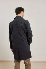 Gabardina color tostado con cuello clásico, cierre delantero con botones y dos bolsillos frontales.
