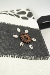 Bolso tipo tote con estampado animal print y detalles de decoración con conchas marinas.