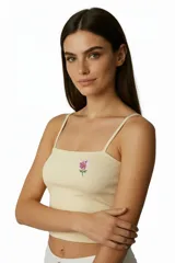 Musculosa blanca de algodón con breteles finos y estampado de una frutilla en el pecho. Corte al cuerpo.