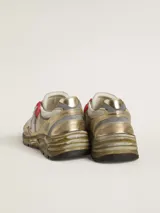 Zapatillas deportivas Golden Goose modelo Running Dad, con diseño moderno y efecto desgastado. Combinan cuero dorado, malla blanca y detalles en gris y rojo. Presentan la estrella distintiva de la marca en blanco y suela robusta.