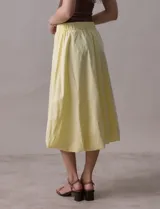 Falda midi color amarillo pálido, de algodón, con pretina ancha elastizada y forro interno a tono.