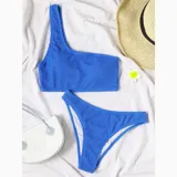 Conjunto de bikini azul con corpiño de un solo hombro y bombacha semi vedetina.