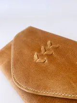 Billetera de cuero color camel con sistema de cierre con broche y monedero externo.