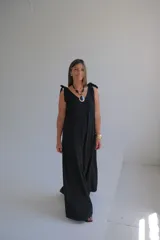 Mono largo negro con escote en V y tirantes anchos con lazos en los hombros.