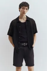 Short de denim negro de cinco bolsillos con corte ajustado en cintura, muslos y bajo, y piernas rectas.