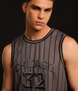 Musculosa deportiva de básquet gris con rayas verticales negras, cuello redondo y sisas con ribete negro. Estampado frontal con la palabra "Chicago" y el número "32".