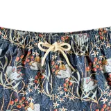 Short de baño azul con estampado floral en tonos blanco, naranja y verde. Tiene elástico en la cintura, cordón ajustable, bolsillos laterales y un bolsillo trasero con botón. Marca Von Braun.