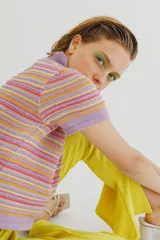 Remera tejida de cuello alto y manga corta con rayas horizontales en tonos lila, amarillo, naranja y rojo.